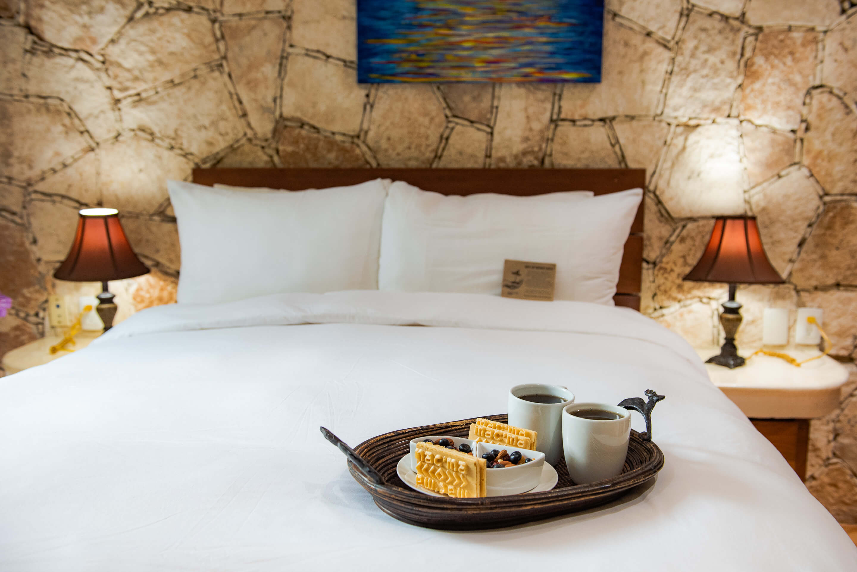 Segundo dormitorio con cama queen y detalles decorativos cálidos